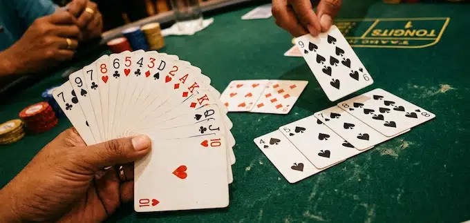 Tongits Online – Players holding playing cards during a traditional Filipino card game